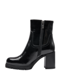 Botín de cuero negro con tacón de bloque, proporcionando comodidad y estabilidad al caminar, estilo casual chic.