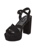 Sandalia de cuero negro con correa ajustable y hebilla en el tobillo, combinable con vestidos midi o faldas vaporosas.