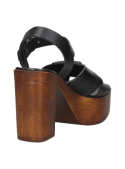 Sandalia femenina en cuero negro con plataforma notable y tiras cruzadas, perfecta para un look bohemio chic.