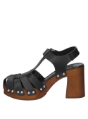 Calzado de cuero negro con remaches metálicos, diseño retro de los años 70, ideal para un look bohemio casual.
