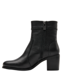 Calzado de cuero negro para mujer, caña media con detalle de borla y tacón ancho, adaptable a looks formales y casuales.