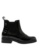 Botín Chelsea de cuero negro para mujer, diseño clásico con detalles brogue, paneles elásticos y suela plana cómoda.