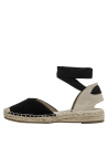 Detalle de tejido beige en el talón de la alpargata de cuero negro, estilo casual.