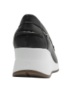 Mocasín de cuero negro con detalle entrelazado en la lengüeta y suela blanca tipo cuña.
