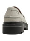 Mocasín beige de cuero para mujer con adorno metálico elegante y suela negra robusta.