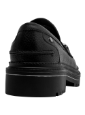 Mocasín de cuero negro para mujer con detalle metálico en la parte superior.