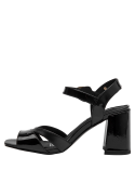 Elegante sandalia de cuero negro con diseño minimalista, perfecta para combinar con trajes sastre.