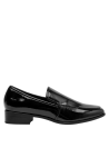Mocasín negro de cuero charol para mujer, destacando su forro de microfibra suave al contacto.