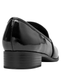 Detalle del mocasín de cuero charol negro, mostrando su construcción minimalista y atemporal.