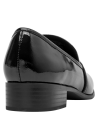 Detalle del mocasín de cuero charol negro, mostrando su construcción minimalista y atemporal.