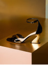 Sandalia de cuero negro con taco aguja y punta abierta, diseño elegante para mujer.