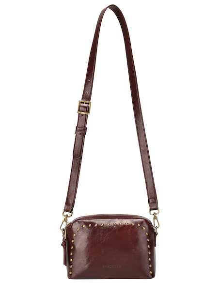 Detalles dorados del bolso burdeos, resaltando su elegancia en un diseño moderno.
