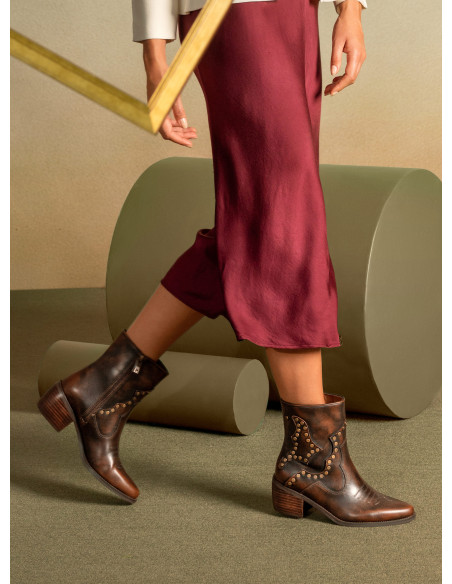 Botín de cuero moro para mujer, estilo casual con detalle de metal y punta puntiaguda.