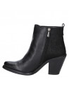 Calzado informal de cuero negro con taco bloque y detalles salvajes, perfecto para destacar en salidas nocturnas.